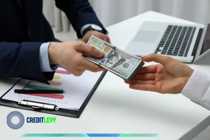 Persona entregando un fajo de billetes a otra, con gráficos y ordenador en el fondo, representando el concepto de CETES y cómo invertir de forma segura.