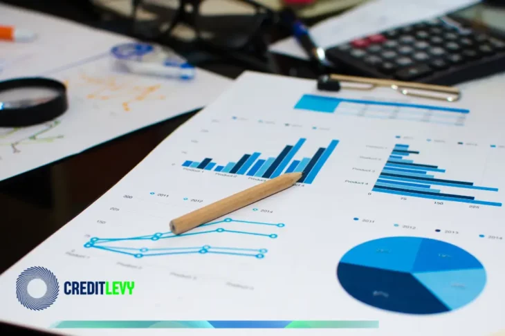 Gráficos financieros impresos junto a una calculadora, bolígrafo y lupa, ilustrando el concepto de planificación financiera y análisis económico.
