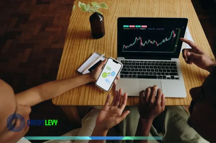 Personas revisando gráficos de inversión en laptop y móvil, representando el aprendizaje de inversiones para principiantes con una guía completa.