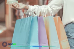 Persona con bolsas de compras y tarjeta de crédito mostrando el concepto de “Cómo aprender a ahorrar”.