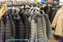 Casacos de inverno em promoção pendurados em araras durante uma liquidação de inverno.