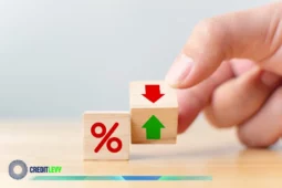 Imagem de blocos de madeira sobre uma mesa: um com o símbolo de “%” e outro com setas vermelha para baixo e verde para cima, ilustrando a variação da Taxa Selic.