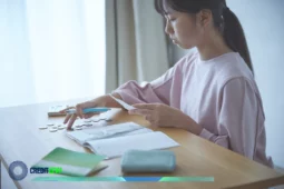 Persona contando monedas y revisando recibos con calculadora y cuaderno para controlar los gastos.