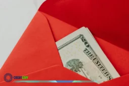 Sobre rojo con billetes de dólar representando el envio de remesas a México.