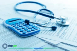 Calculadora azul e estetoscópio sobre papéis de despesas médicas, simbolizando o cálculo de custos de um Plano de Saúde.