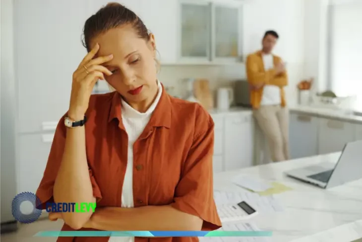 Mujer preocupada revisando documentos en la cocina, simbolizando la importancia de planificar bien el uso del aguinaldo para evitar deudas.