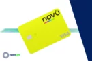 Cartão Novücard amarelo com bandeira Visa sobre fundo verde degradê.