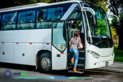 Passageira embarcando em ônibus de viagem, imagem ilustrando compra de passagem de ônibus para viagens rodoviárias.